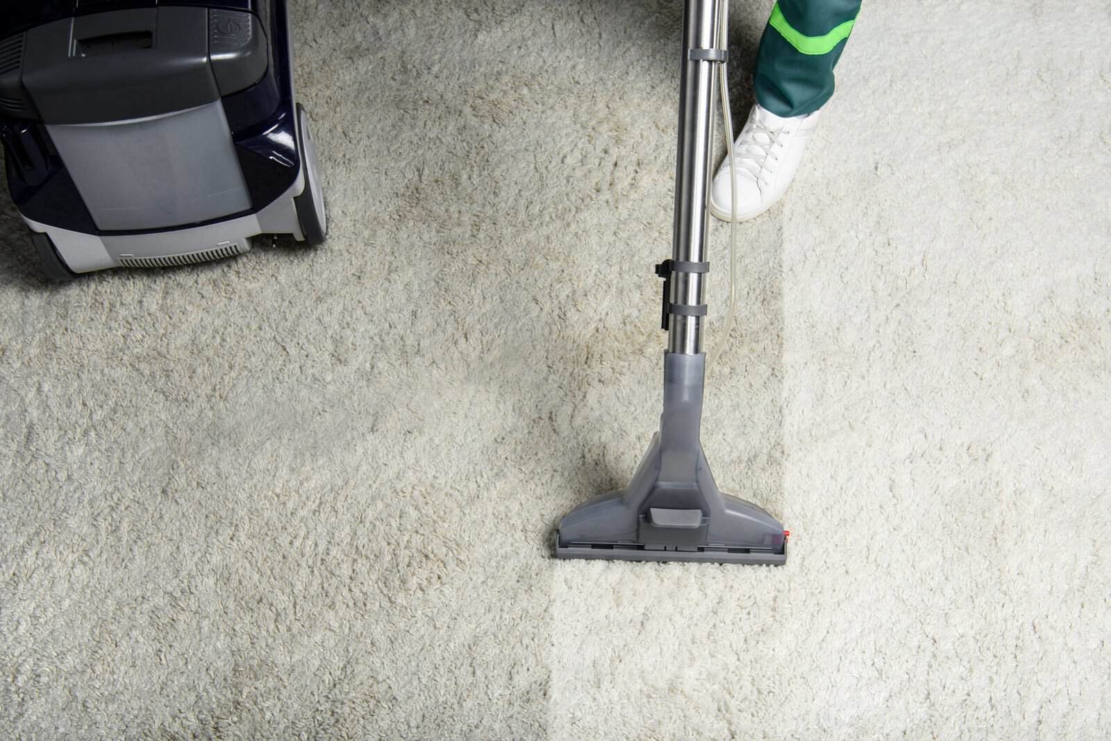 Professional carpet cleaning with vacuum and cleaning tools in progress.
