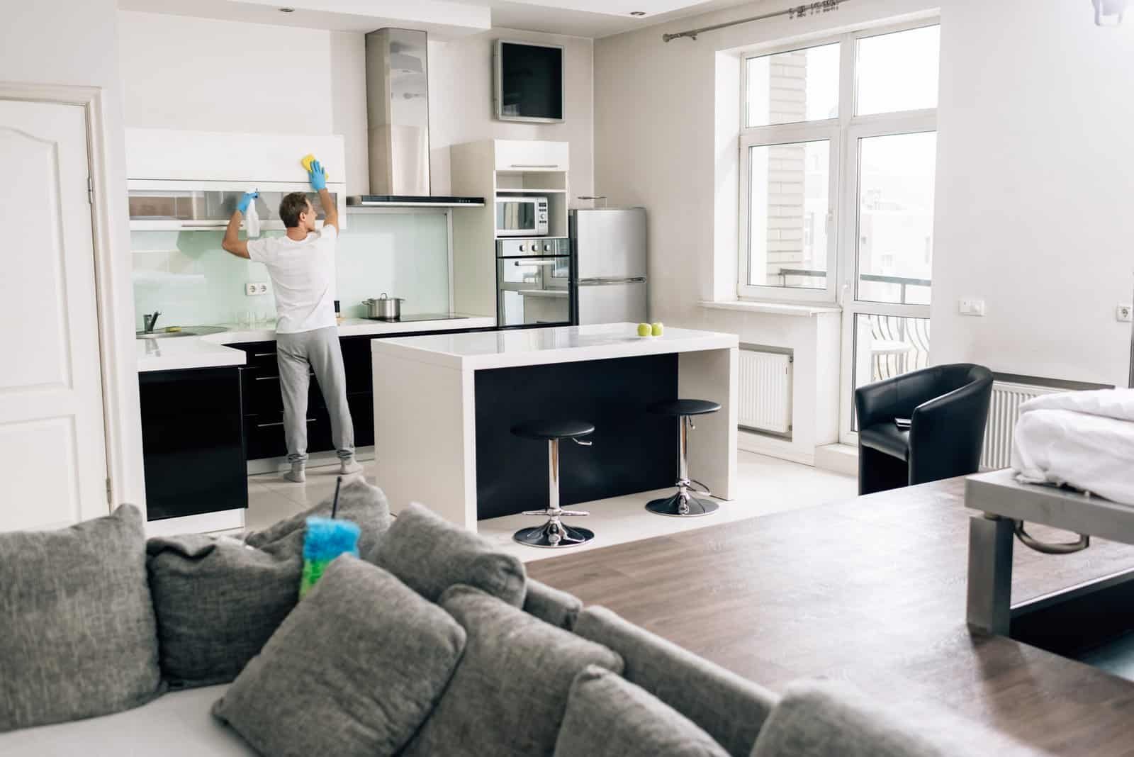 Modern kitchen and living room with large windows and contemporary furniture.